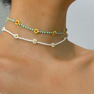 Close-up of two beaded flower chokers on a person's neck.