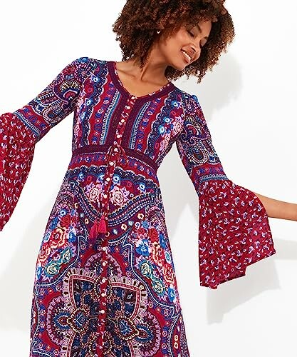 Woman wearing colorful bohemian floral dress with flared sleeves.