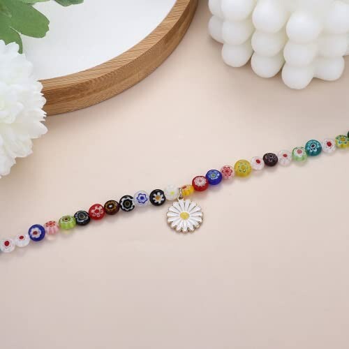 Colorful beaded bracelet with a flower charm on a beige background.