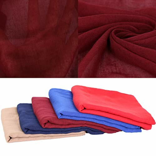 Stack of colorful fabric scarves in various shades.
