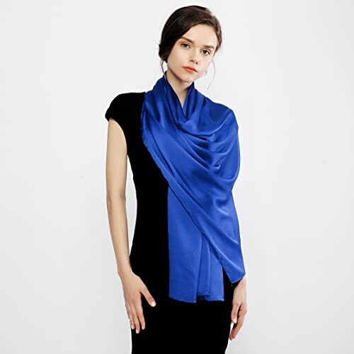 Woman wearing a blue silk scarf over a black dress