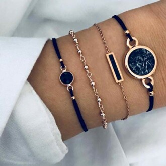 Wrist adorned with elegant bracelet set in gold and black.