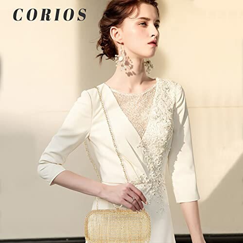 Woman in an elegant white dress with lace details and a gold clutch