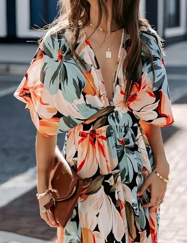 Woman in floral maxi dress with deep V-neck, holding a brown clutch.