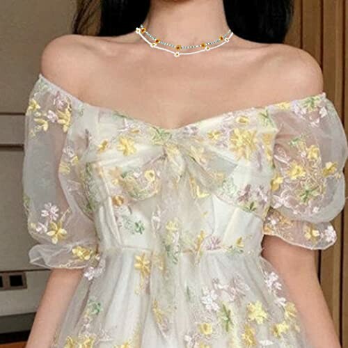 Woman wearing a floral off-shoulder dress with sheer puff sleeves.
