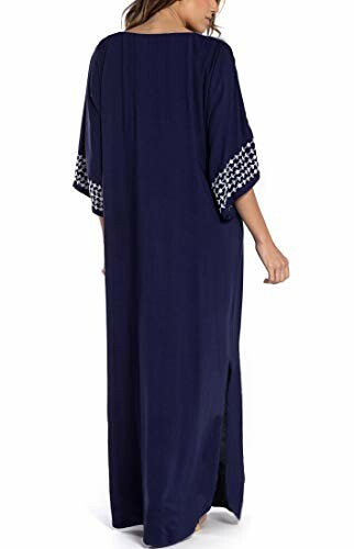 Woman in navy blue kaftan dress with patterned sleeves.