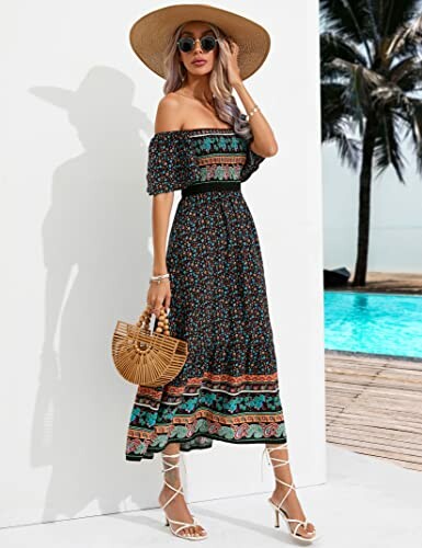 Woman in a floral dress and sun hat by a poolside