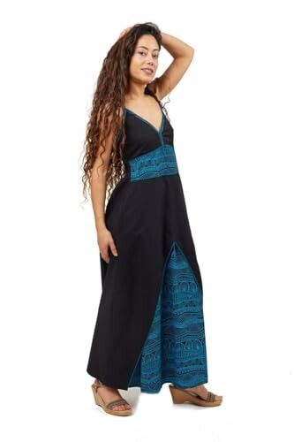 Woman in a long black and blue dress with hand on head.