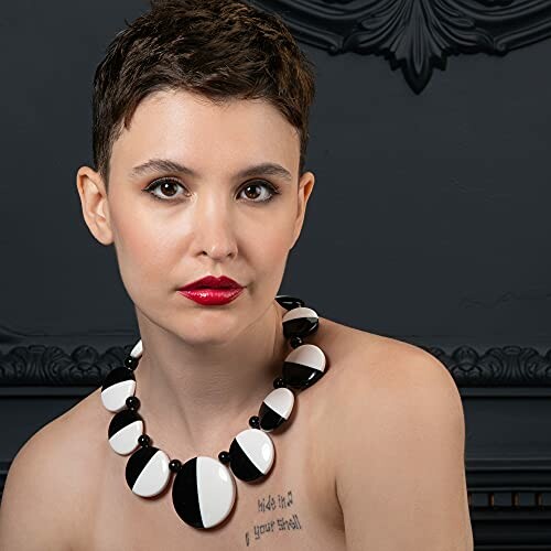 Woman wearing a bold black and white necklace.