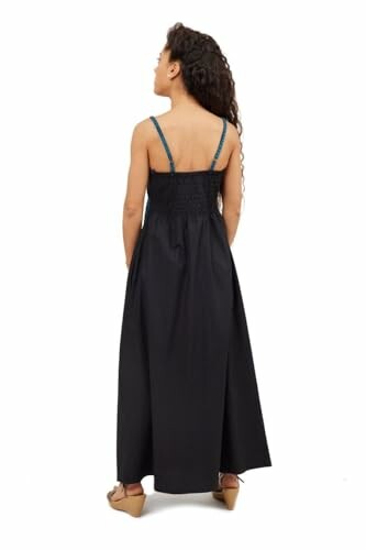 Woman wearing a long black dress, back view