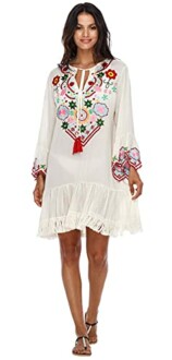 Woman wearing a white dress with colorful embroidery and ruffled hem