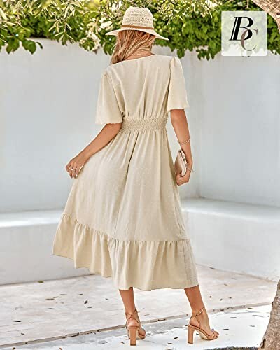Woman in a beige summer dress and hat standing outdoors