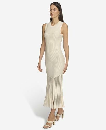 Woman wearing a sleeveless beige dress with pleated skirt.