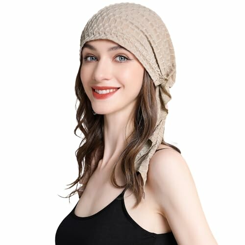 Smiling woman in a beige headscarf.