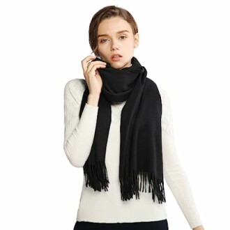 Woman in white sweater wearing a black scarf.