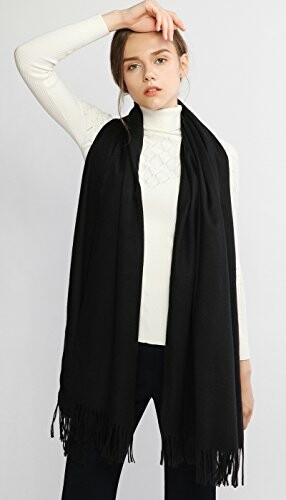 Woman wearing a long black scarf over a white sweater.