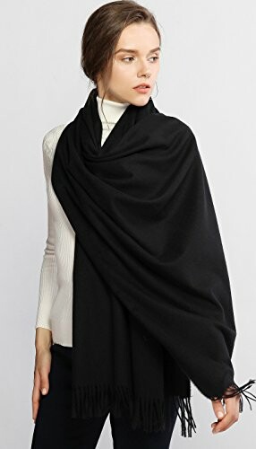 Woman wearing a black shawl over a white sweater.