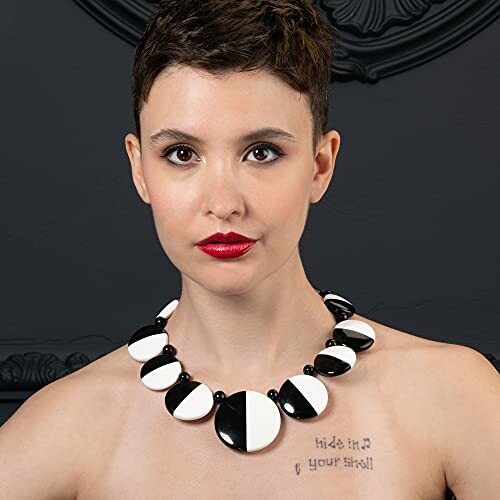 Woman wearing a bold black and white necklace.