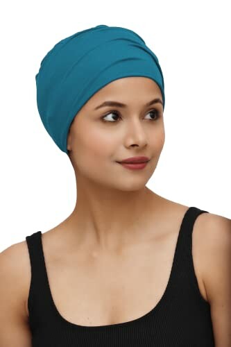 Woman wearing a blue headwrap and black top