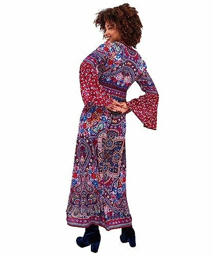 Woman in a colorful patterned maxi dress with bell sleeves.