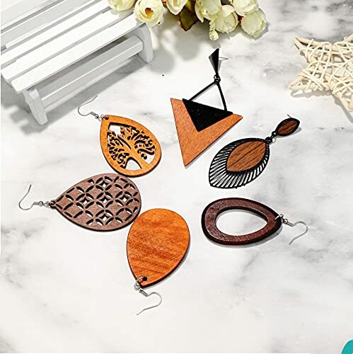Assorted wooden earrings on marble surface